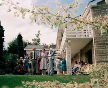 Guests at a Conservative Party fundraiser mingle on a lawn outside a house