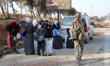 Displaced Syrians carry their belongings out of Aleppo on the third day of a rebel offensive.