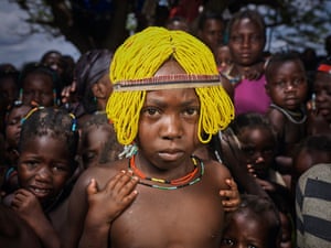 a girl in a yellow beaded wig looks at the camera