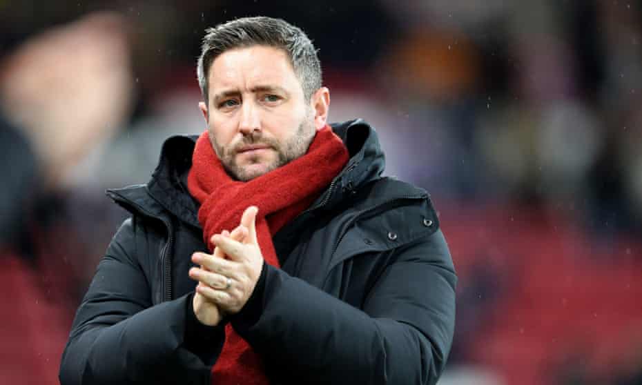 Lee Johnson in a red scarf applauds fans in a previous match as Sunderland manager