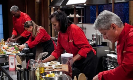 four cooks in red chefs jackets cooking