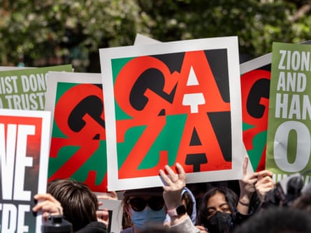 people hold signs saying “gaza” in red letters on a green, black and white background - the image is similar to the pop art image of the word “love” by robert indiana