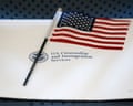 A small American flag rests on a document from U.S. Citizenship and Immigration Services