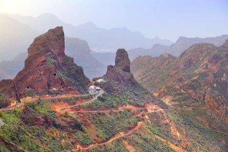Winter view of Gran Canaria landscape - rocky pinnacles a road zigzagging and distant mountains in sunshine