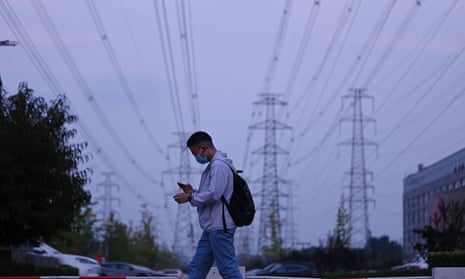 A man walks below power lines in Beijing on 28 September