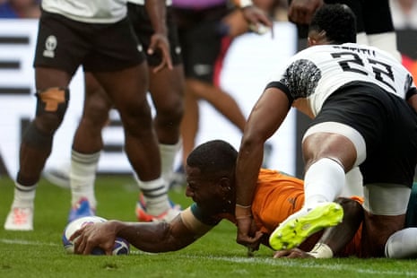 Australia's full-back Suli Vunivalu (C) grounds the ball to score a try.