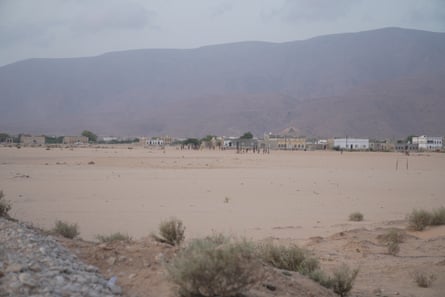 Buildings can be seen at the foot of a mountain in a desert landscape