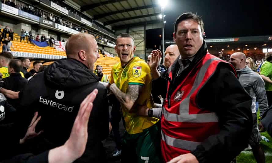 Swindon players try to get off the field at Vale Park. Their manager claimed home fans had ‘physically and verbally abused’ his players