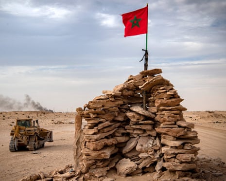 A stone lookout in the desert with a bulldozer next to it