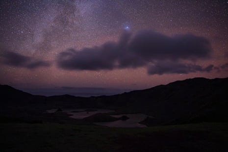 Starry sky with the Milky Way glowing above an island
