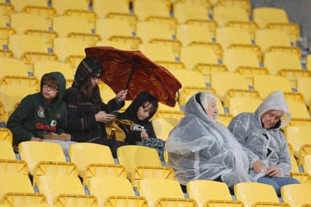 Fans with an umbrella and wet-weather gear prepare for rain prior to a Women’s World Cup match in Wellington