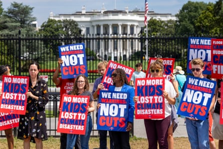 people hold signs with the white house in the background
