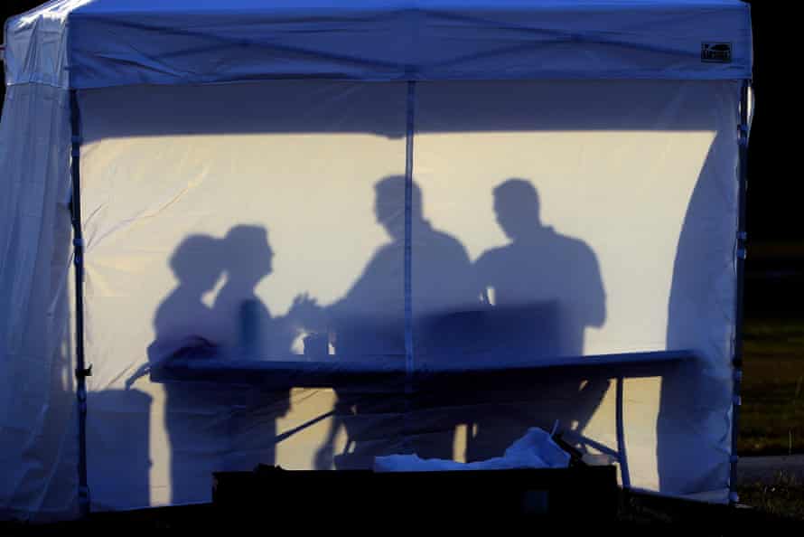 Medical personnel are silhouetted against the back of a tent at a coronavirus test site in Tampa, Florida.
