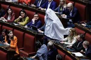 Person draped in sheet with MPs sitting around