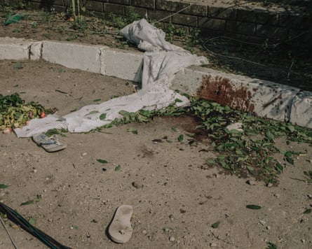 Blood spattered on the kerb of a pavement with a white blanket discarded next to it
