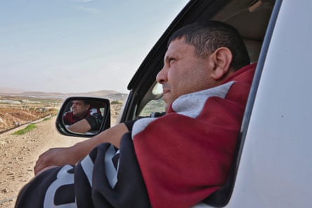 Arafat Bsharat gazes out of his open car window at the farmland