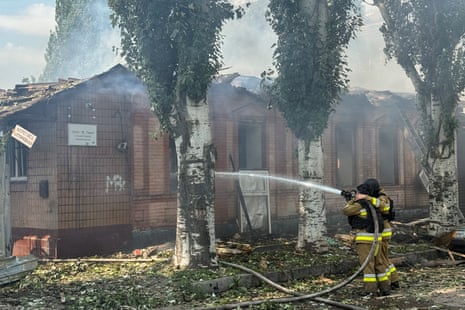 Rescue workers extinguish a fire after a Russian drone strike on July 7, 2025 in Zaporizhzhia, Ukraine.