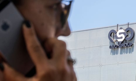 A woman uses her iPhone in front of an NSO Group building in Herzliya, near Tel Aviv