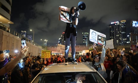 Einav Zangauker stands on the roof of a car during a demonstration by hostages’ relatives and supporters in Tel Aviv