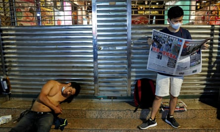 A supporter of Apple Daily newspaper reads a copy.