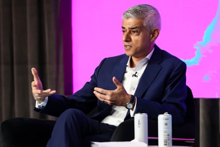 Sadiq Khan sat on stage in a suit, but no tie
