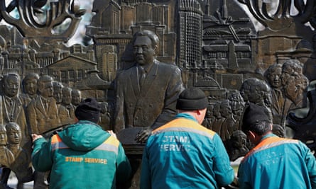 Council workers clean a bas-relief of Nursultan Nazarbayev in Almaty