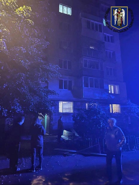 مردم در مقابل یک ساختمان مسکونی در کیف که در اثر حمله موشکی روسیه آسیب دیده است، ایستاده اند.