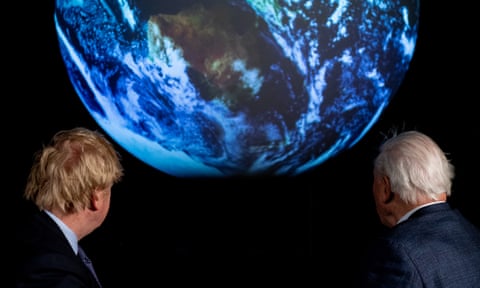 Boris Johnson (left) and British broadcaster and naturalist Sir David Attenborough look at a projection of planet Earth during the launch of the COP26 UN Climate Summit.