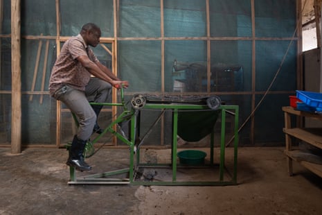 A man on a bike attached to a green contraption.
