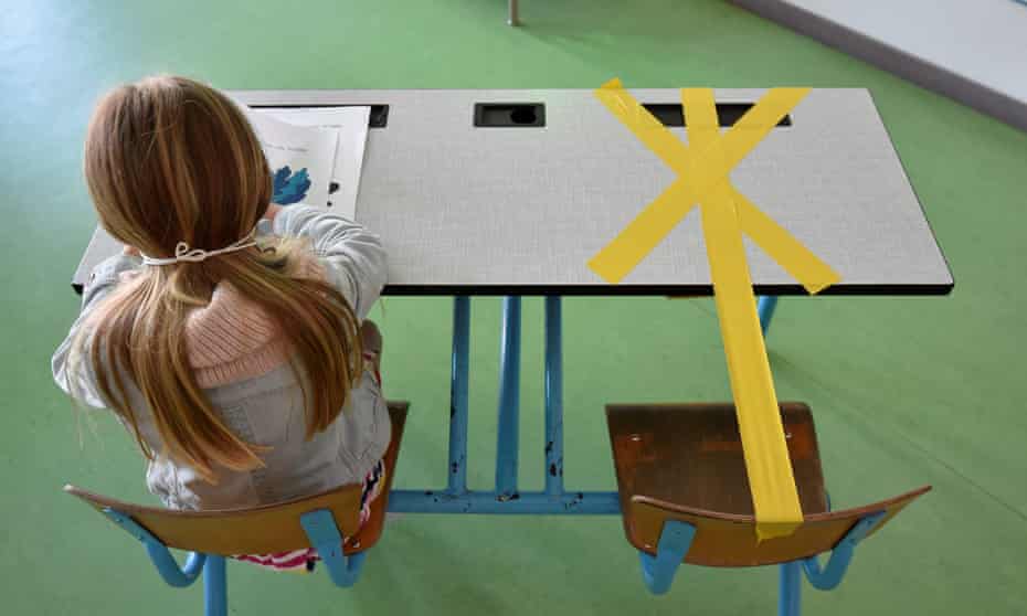 A pupil in Belgium works as half of her desk is marked with a tape to ensure that safe distance is kept