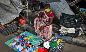 A woman selling face masks and caps waits for customers in Kolkata, India, Sunday, 2 August 2020.