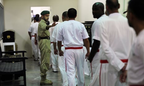 A policeman directs prisoners at Central Prison in Dubai, United Arab Emirates.