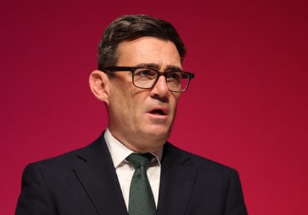Andy Burnham in a suit with a red background