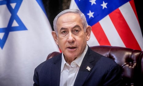 Benjamin Netanyahu speaking with Israeli and US flags behind him