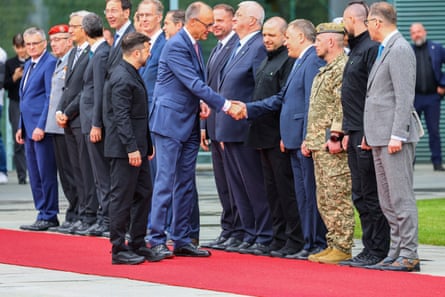 Friedrich Merz shakes hands with members of the Ukrainian delegation alongside Volodymyr Zelenskyy in Berlin.
