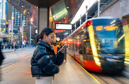 A woman smartphone while waiting for train at railway station