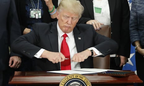 Donald Trump prepares to sign an executive order to build a border wall, on 25 January