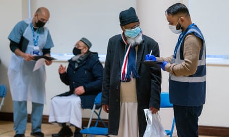 People attend a temporary coronavirus vaccination centre at the East London Mosque, in Whitechapel, London.