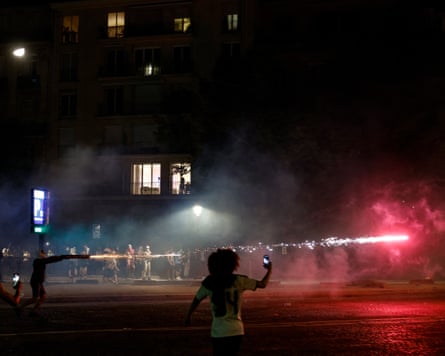 A PSG supporter shoots off a firework on Avenue Foch