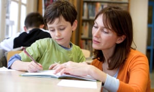 Teacher working in the classroom with young boy
