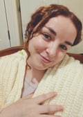 Rhiannon wears a cream crochet shawl over her shoulders. She has long, curly red hair tied back from her face with a ringlet hanging forward.