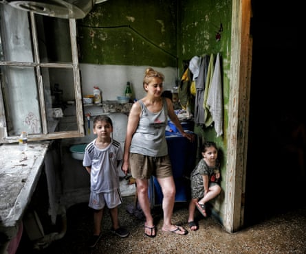 A woman with two children in an old kitchen