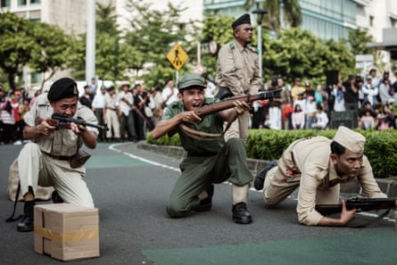 Actors perform a reenactment of the 1949 General Offensive on Surakarta, one of the last major battles after Indonesia’s 1945 independence proclamation against Dutch forces that refused to recognize it, during National Veterans Day commemorations on a street in Jakarta on August 10, 2025.