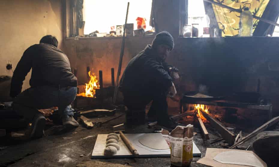 Afghan migrants cook inside an abandoned industrial plant in Bihać, Bosnia-Herzegovina