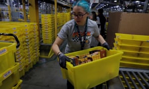A worker moves a bin filled with products inside an Amazon centre in New Jersey.