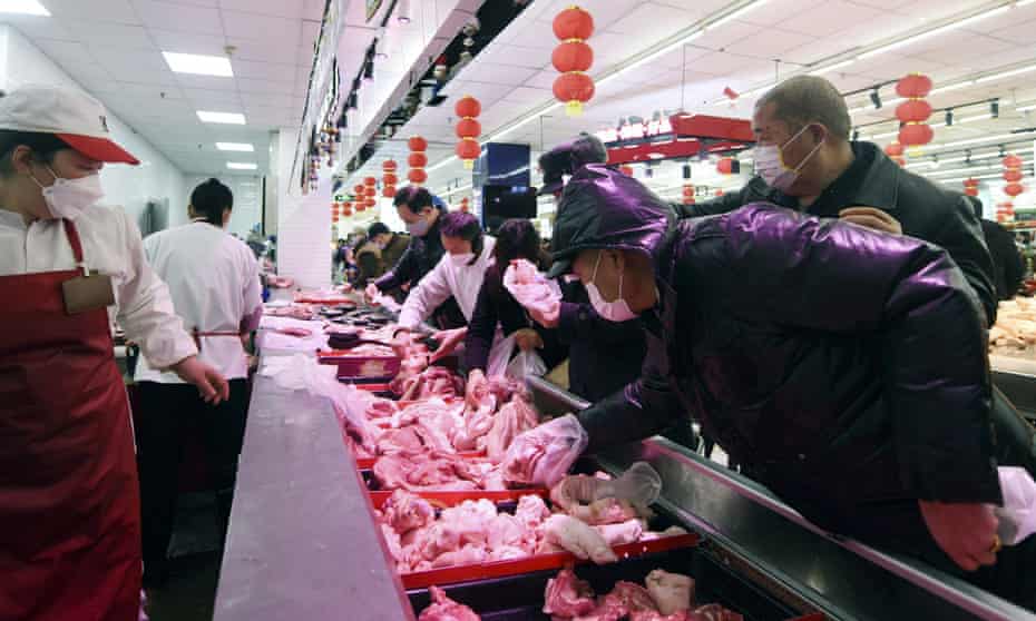 People wearing masks buy meat at a supermarket in Hangzhou in east China’s Zhejiang province in February. China has banned exports of meat from four Australian abattoirs.