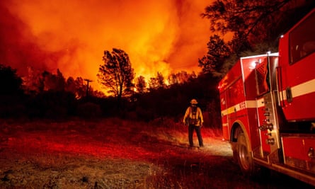 Butte county firefighters watch as flames tower over their truck at the Bear fire in Oroville, California, on 9 September.
