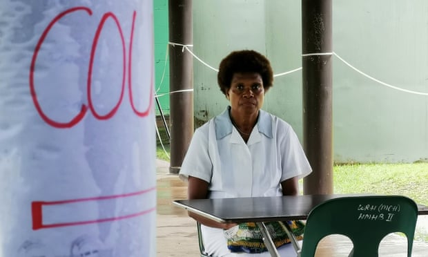 A nurse sits at a screening station for anyone presenting with a cough or flu like symptioms in PNG’s East New Britain province.