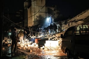 Civiles y combatientes examinan los escombros de un edificio derrumbado en busca de víctimas y sobrevivientes en la ciudad de Jindires, Siria.