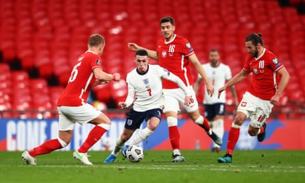 England’s Phil Foden runs with the ball under pressure from Jakub Moder and Grzegorz Krychowiak of Poland